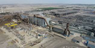 Vista panorámica de una planta de procesamiento en Arequipa con múltiples señales de obligación azul indicando el EPP requerido.