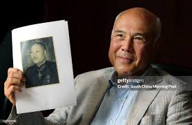 Adrian Fu, Chief executive of KHI Holding Group, holds a photo of his...  News Photo