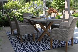 In the dining room, a table made from reclaimed wood delivers a rustic look. Composite Rectangle Dining Table With Trestle Teak Wood Base