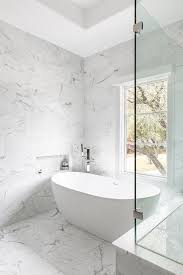 A Marble Tiled Niche Surrounded By Marble Wall Tiles Is Positioned Above An Ov In 2020 Marble Wall Tiles Free Standing Bath Tub Bathroom Tub Remodel