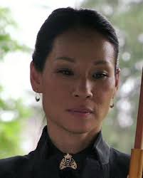 Joan Watson wearing a bee brooch