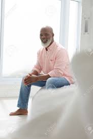 There is a vast array of standing devices to choose from. Side View Of African American Man Sitting On The Bed In The Bedroom Stock Photo Picture And Royalty Free Image Image 126953824