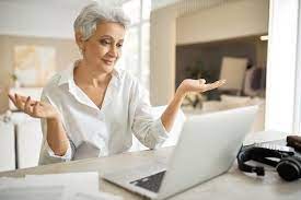 Free Photo | Emotional mature female employee in white shirt working from  home, sitting at table with laptop, making helpless gesture, shrugging  shoulders, having virtual online chat