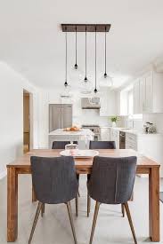 Gray Slipcovered Dining Chairs Sit On Either Side Of A Stained Oak Dining Table Placed Beneath Linear Stagger Oak Dining Table Dining Room Design Dining Chairs