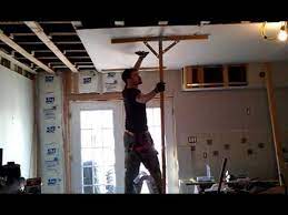 He screws a short piece of 2x4 into the wall studs leaving just enough room to slide one. That Is How It Is Done Sheetrock To Ceiling With Two Hands And A Head Youtube