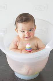 The more they hear your voice, the more they'll get used to listening to you and lower your baby gently into the bowl or bath using one hand to hold their upper arm and support their head and shoulders. Baby Sitting In Bath With Tube Of Colorful Soap Stock Photo Dissolve