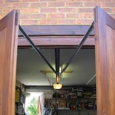 The motors mount above the opening, without a track along with the ceiling, leaving the space open from floor to ceiling. Automating Side Hinged Garage Doors Hormann Marantec Garador Electric Side Hinged Doors