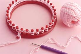 Next, use a knitting hook (which comes with most looms) to lift the bottom loop of yarn up and over the peg, leaving the top loop in place. What Is Loom Knitting And How Does It Work