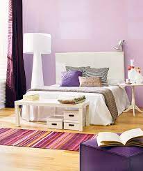 A stylish bedroom with a grey statement bed, white furniture, a colorful scale chandelier and pillows plus purple and grey textiles. Bedroom Decor In Purple My Decorative