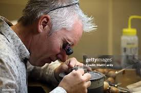 Chief engraver Gordon Summers looks at a cast for the new coin to... News  Photo