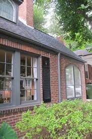 For example, if your brick home is red and tinged with brown, the warm undertones might contrast too sharply with a cool stark white trim. Red Brick Grey Trim And Black Shutters But The Real Treat Is The House Staging Brick Exterior House Orange Brick Houses Red Brick House