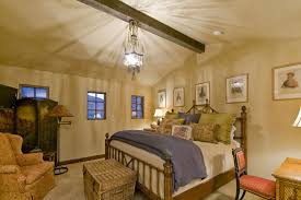 Track lighting and sloped ceilings go hand in hand. Hanging A Ceiling Fan For Traditional Bedroom And Bamboo Headboard Beige Walls Chandelier Exposed Beams Folding Screen Foot Of The Bed Painted Ceiling Pendant Lighting Sloped Ceiling Trunk Vaulted Ceiling Wall Art