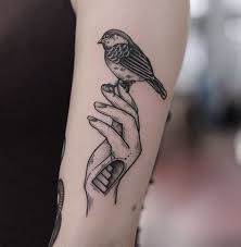 Small Bird Tattoo On Hand A Hand Holding A Small Sparrow Tattoo On The Left Upper Arm Hand Tattoos Small Sparrow Tattoos Bird Hand Tattoo