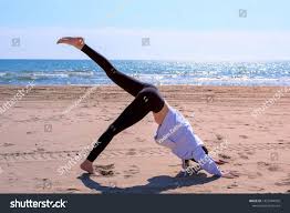 Saturday morning yoga will take you under the sea! Girl Is Practicing Yoga On Sea Sand Beach Young Woman Is Making Downward Facing Dog Pose In Yoga Side View Sport Dog Poses Get In Shape Downward Facing Dog