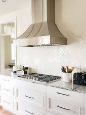 It is about the fresh and clean white subway tile backsplash. Glossy Tiles Basic Subway Tile In A Herringbone Pattern Cover The Entire Wall Behind The Herringbone Kitchen White Kitchen Design Backsplash Tile Design