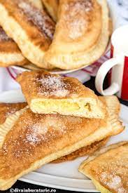 Aluat, cca 600 g faina de cozonac baneasa, coaja de lamaie si portocala, 3 galbenusuri, 4 linguri zahar, 250 ml lapte caldut, 4 linguri apa minerala calduta, 3 linguri smantana grasa, 1/2 lingurita sare, 50 ml ulei, 1 plic de drojdie uscata 7 g, 1 lingurita de zahar, 50 g stafide, umplutura. Branzoaice La Tigaie Diva In Bucatarie
