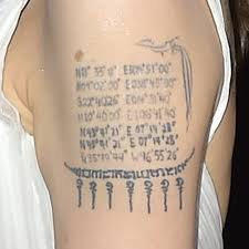 Gothic script tattoo on upper back: Angelina Jolie S Geographical Coordinates Arm Tattoo