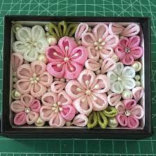 作品には 一越ちりめん を使用しております 布はピンク色 パールピンク もえぎ色 白色を使用しています ギフトボックスにつまみ細工とパールを散りばめました 春らしく桜をイメージした配色に仕上げました お家のインテリア 結婚祝いやお誕生日などのプレゼ