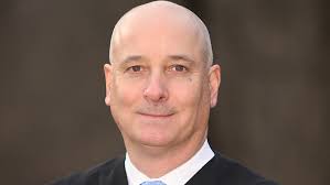 Democrat groups opposes new term for Justice Wood after party switch