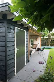 buitenkant zwart binnenkant wit houtkachel en houten balken zichtbaar tuin tuin nieuwbouw tuin inspiratie