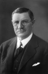 Portrett av den norske næringslivslederen Elias Cathrinus Kiær (1863-1939).  Da dette fotografiet ble tatt skal Kiær ha vært i slutten av 60-åra. Han  var kledd i mørk dress med vest, kvit skjorte og mørkt slips. Det mørke  håret var sidestrøket, barten grånende ...