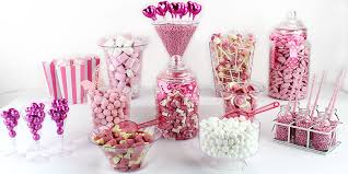 En la barra de chocolate hay moldes con porciones de postres y galletas cubiertas de crema rosa. Rosa Candy Bar Partycity De