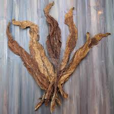 Dried tobacco leave and cut tobacco with cigar and whiskey rum on wood background on vintage dark table. Whole Leaf Tobacco Dark Air Cured Tobacco 1lb