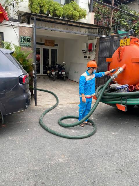 Xử lí hầm cầu bằng cách kéo ống dài 50 mét của công ty Đô Thị Xanh Phương Anh