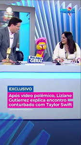 Apresentadores de TV em estúdio com boneco colorido e texto sobre Liziane Gutierrez e Taylor Swift.