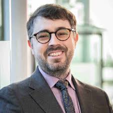 The Merging Galaxy Cluster Environment Affects the Morphology of Radio  Active Galactic Nuclei