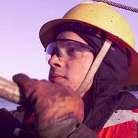 A member of the Japanese Self Defense Force Diving Team is fitted with a  MK-21 dive helmet aboard the Crowley 450-10 barge, during recovery  operations for the Japanese fishing vessel Ehime Maru -
