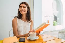 Young Woman Reading A Book At Coffee Shop In 2020 Coffee Shop Woman Reading Books To Read