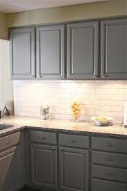 Gray marble countertop in a black and white kitchen. Grey Cabinets White Subway Tile Backsplash Corian Countertops Grey Kitchen Cabinets