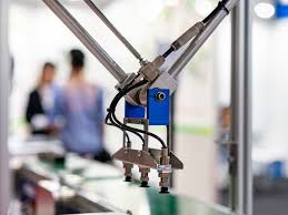 테스트 핸들러 내부의 로봇 팔이 트레이에 담긴 반도체 칩을 집어 올려 테스트 소켓 보드(Hi-Fix)에 장착하는 고속 동작 모습