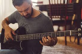 Man Playing Bass Guitar Sitting On The Floor By Silvia Cipriani