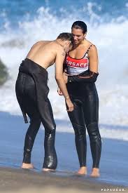 Dua lipa took boyfriend anwar hadid to the grammy awards 2020 as her plus one and the pair looked super cute as they posed for pictures on the red carpet together. Dua Lipa Wore A Bold Versace Swimsuit During Her Steamy Surfing Date With Anwar Hadid Versace Swimsuit Dua Lipa