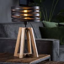 Cette lampe est construite à partir de tuyaux de fer noir de style industriel lourd. Lampe De Table Un Abat Jour Cylindrique En Torsades De Metal Monte Sur Pieds Croises En Bois De Style Industriel Retro