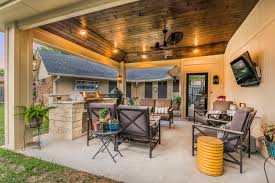 Stone brick walls, arched terrace, candle chandelier, distressed wood ceiling and stone tile floors. Patio Cover And Outdoor Kitchen In Grand Prairie Texas Custom Patios