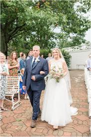 Bride Walking Down The Aisle On Her Wedding Day At An Outdoor Summer Ceremony The Flowerman Navy Suit Lace Two Piece Weddi Farm Wedding Wedding Bridal Formal