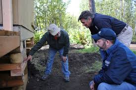 Circle, AK-- Mennonite Disaster Service Director John Eshleman (L) points  out the elevation of this replacement home after the disaster survivor  decided to elevate up to higher ground away from the repetitive