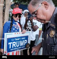 Atlanta, Georgia, USA. 24th Aug, 2023. A supporter of former President  Donald Trump holds a sign that says TRUMP MAKE AMERICA GREAT AGAIN as a  large crowd of Trump supporters rallied at