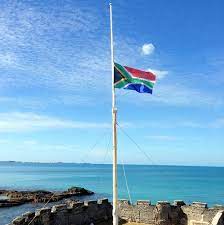 There is a central green band that splits into a horizontal y in the middle bordered by white and gold bands. Mandela Flags At Half Mast Condolence Book Bernews