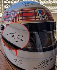 Com ajuda da esposa, Schumacher assina capacete em rara aparição em tributo  da F-1