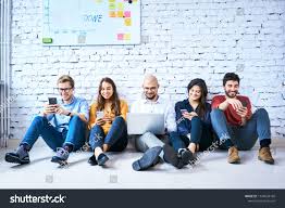 Group Of University Students Sitting On Floor Together During Break And Using Smartphones Or Laptop Studen University Student Student Print Designs Inspiration