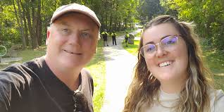 Registered Psychotherapist and Trauma Therapist Kaitlyn Baldwin stands with  our media producer and journalist, John Ironside, at the gate to Berczy  Park. Yesterday, officers of the Barrie Police Service arrested both of