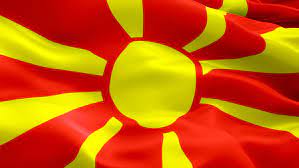 The national flag of macedonia consists of stylized yellow sun centered on red field with its eight broadening yellow rays extending out in all directions and end at the edges of the flag. Shutterstock