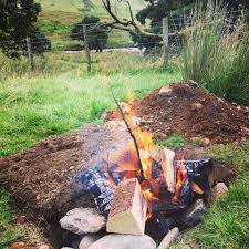 Dig a hole in the ground, fill it with fire, add a large animal, cover and cook. The Grazer Pit Cooking Lamb In The Ground