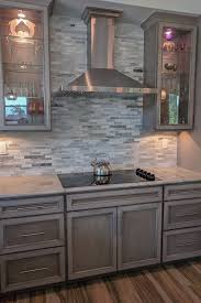 The best gray and greige paint colours for cabinets. Glass Doors Frame This Sleek Cooktop And Hood Featuring Our New Storm Stain Grey Cabinets Grey Painted Kitchen Gray Stained Cabinets