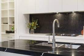 The lighting fixture enhances the luxurious look of this gray kitchen! Best Colors For Quartz Countertops With White Cabinets