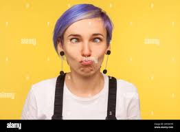 Portrait of comic hipster girl with violet short hair looking cross eyed,  making silly awkward face expression, having fun and playing fool. isolated  Stock Photo